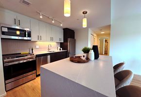 Dundas apartment for rent - A modern kitchen with a white island and stainless steel appliances.at Imperium, Dundas Ontario
