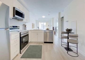 Kitchener apartment for rent - A modern kitchen with white cabinets and stainless steel appliances.