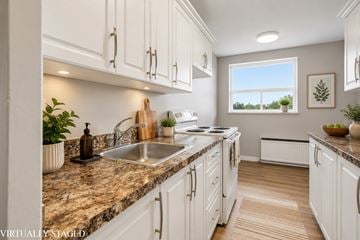 Hamilton apartment for rent - A kitchen with white cabinets and a marble countertop.