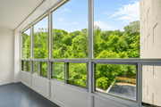 Hamilton apartment for rent - A room with large windows overlooking a green forest.