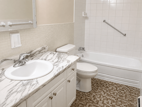 Dundas apartment for rent - A white toilet sits next to a sink in a bathroom.