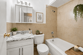 Hamilton apartment for rent - A bathroom with a white tub, toilet, and sink.