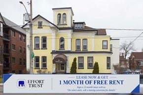 Kitchener apartment for rent - A large yellow building with a sign in front that says "Lease Now & Get 1 Month of Free Rent".