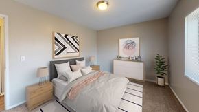 Independence apartment for rent - A bedroom with a bed, dresser, nightstand, and lamp.