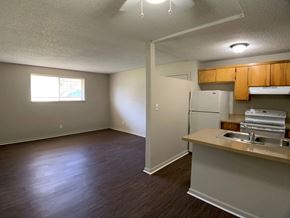 Kansas City apartment for rent - A kitchen area with a refrigerator, sink, and cabinets.