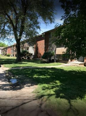 Kansas City apartment for rent - A tree in front of a building with a brick wall.
