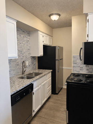 Shawnee apartment for rent - A kitchen with black appliances and white cabinets.