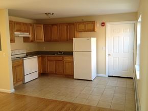 Poughkeepsie apartment for rent - A kitchen with wooden cabinets and white appliances.