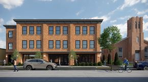 Beacon apartment for rent - A modern brick building with a parking lot in front.