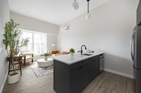 New Paltz apartment for rent - A kitchen with a grey island and a refrigerator on the right.