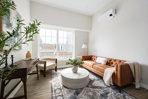 New Paltz apartment for rent - A living room with a brown couch and a round coffee table.