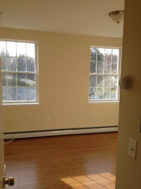 Poughkeepsie apartment for rent - A room with a wooden floor and two windows.
