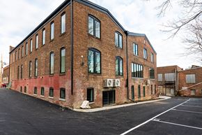 Newburgh apartment for rent - A large brick building with a parking lot in front.