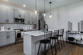 Poughkeepsie apartment for rent - A modern kitchen with a white island and black bar stools.