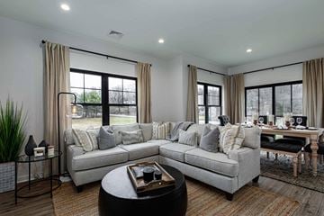 Poughkeepsie apartment for rent - A modern living room with a grey sofa, a coffee table, and a dining table set up.