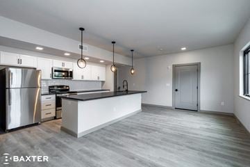Poughkeepsie apartment for rent - A modern kitchen with a stainless steel refrigerator and a white island.