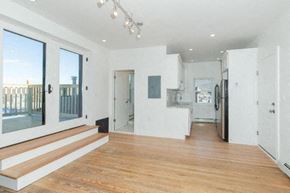 Beacon apartment for rent - A spacious, well-lit room with wooden floors and white walls.