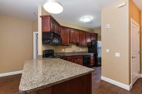 Poughkeepsie apartment for rent - A kitchen with granite countertops and wooden cabinets.