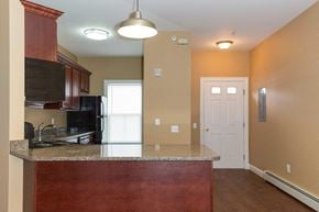Poughkeepsie apartment for rent - A kitchen with a granite counter top and a black refrigerator.