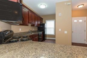 Poughkeepsie apartment for rent - A kitchen with granite countertops and wooden cabinets.