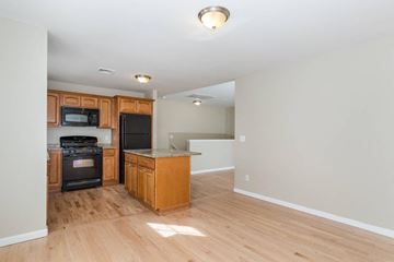 Poughkeepsie apartment for rent - A kitchen with wooden cabinets and a black oven.