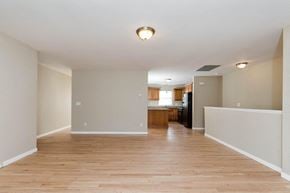 Poughkeepsie apartment for rent - A spacious room with wooden floors and a kitchen area in the background.
