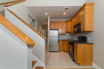 Poughkeepsie apartment for rent - A kitchen with wooden cabinets and a stainless steel refrigerator.
