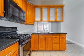 Poughkeepsie apartment for rent - A kitchen with wooden cabinets and black appliances.