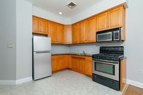 Poughkeepsie apartment for rent - A kitchen with wooden cabinets and black appliances.
