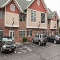 Poughkeepsie apartment for rent - A red and white building with a parking lot in front.
