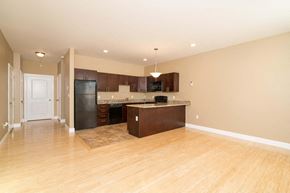 Poughkeepsie apartment for rent - A kitchen with a black refrigerator and wooden floors.