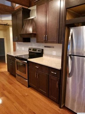 Catskill apartment for rent - A kitchen with a stainless steel refrigerator and wooden cabinets.