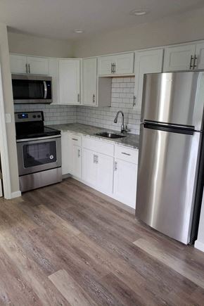 Poughkeepsie apartment for rent - A kitchen with a stainless steel refrigerator, microwave, oven, and cabinets.