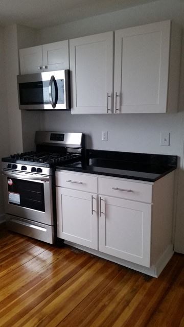 Poughkeepsie apartment for rent - A kitchen with a stove top oven and microwave.