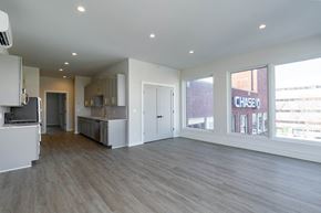 Poughkeepsie apartment for rent - A spacious, empty room with light wood flooring and white walls.