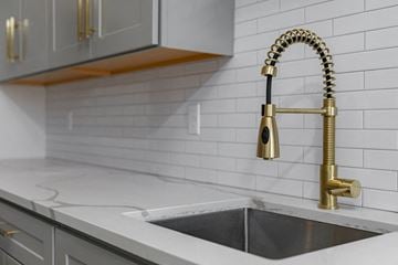 Poughkeepsie apartment for rent - A kitchen sink with a gold faucet and a white countertop.
