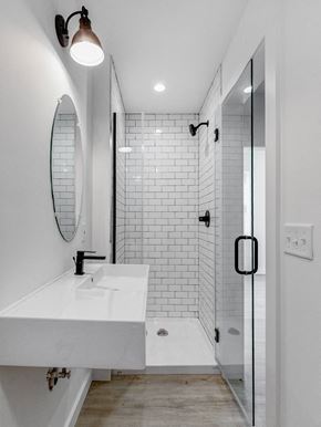 Poughkeepsie apartment for rent - A white sink in a modern bathroom with a glass shower door.