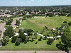 Mcallen apartment for rent - A large green field with trees and a road.