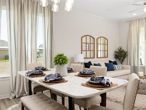 Mcallen apartment for rent - A dining room with a table set for two and a couch with blue pillows.
