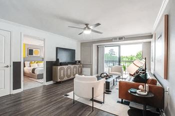 A living room with a white chair and a brown couch.