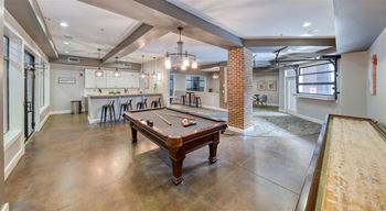 A room with a pool table and a bar area