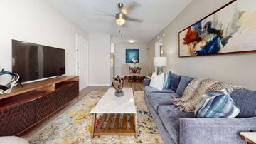 Duluth apartment for rent - A living room with a grey couch, a wooden coffee table, and a painting on the wall.