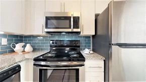 Smyrna apartment for rent - A kitchen with a black stove top oven and a black refrigerator. at Cumberland Pointe, Georgia, 30080