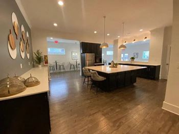 A modern kitchen with dark wood floors and a white countertop.