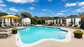 Atlanta apartment for rent - A large outdoor swimming pool surrounded by lounge chairs and umbrellas.