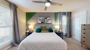 Atlanta apartment for rent - A bedroom with a large bed and a ceiling fan.