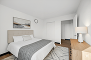 Chicago apartment for rent - A bedroom with a large bed and a wooden nightstand at Fullerton Court Apartments, Chicago, IL
