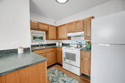 Chicago apartment for rent - A kitchen with wooden cabinets and a white refrigerator at Fullerton Court Apartments, Chicago, IL 60614