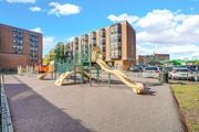 Chicago apartment for rent - A playground with a yellow slide in front of a building at Fullerton Court Apartments, Chicago, IL 60614