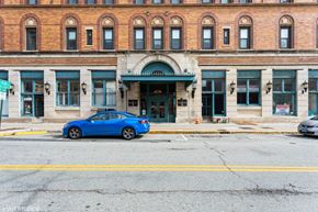 New London apartment for rent - A blue car is parked in front of a building with a green awning at Mohican Apartments, New London, Connecticut